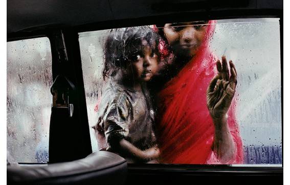 Femme et enfant regardant par la fenêtre d'un taxi à Bombay